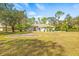 One-story house with a spacious yard, palm trees, and a two-car garage at 610 Woodview Way, Bradenton, FL 34212