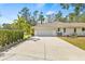 White garage with driveway and lush green hedge at 610 Woodview Way, Bradenton, FL 34212