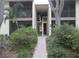 Condominium exterior showcasing well-maintained landscaping and access to upper-level units at 622 Bird Bay S Dr # 101, Venice, FL 34285