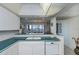 Kitchen boasts teal countertops, white cabinets, and a dishwasher at 627 Alhambra Rd # 601, Venice, FL 34285