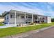 Mobile home exterior with covered patio and landscaping at 6401 Floral Ct, North Port, FL 34287
