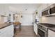 White kitchen with stainless steel appliances and wood floors at 6401 Floral Ct, North Port, FL 34287