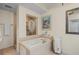 Bright bathroom showcasing a soaking tub, separate shower, and towel rack at 9203 Griggs Rd # B202, Englewood, FL 34224