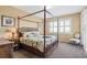 Bedroom with a four poster bed, plantation shutters, and decorative furnishings at 9203 Griggs Rd # B202, Englewood, FL 34224