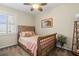 Cozy bedroom with a rattan bed frame, patterned bedding, a ceiling fan, and plantation shutters at 9203 Griggs Rd # B202, Englewood, FL 34224