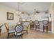 Dining area with a glass-top table and four upholstered chairs next to kitchen at 9203 Griggs Rd # B202, Englewood, FL 34224