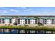 Waterfront condo buildings overlooking a serene pond with lush green surroundings at 9203 Griggs Rd # B202, Englewood, FL 34224