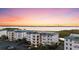Beautiful sunset view of condo buildings with green roofs near the water at 9203 Griggs Rd # B202, Englewood, FL 34224