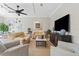 Comfortable living room featuring neutral tones, ceiling fan, and media console at 9203 Griggs Rd # B202, Englewood, FL 34224