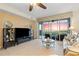 Comfortable living room area with tile flooring, media center, and sliding doors to outdoor patio at 9203 Griggs Rd # B202, Englewood, FL 34224
