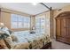 Bright main bedroom featuring a canopy bed with tropical bedding, balcony access, and plantation shutters at 9203 Griggs Rd # B202, Englewood, FL 34224