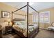 Comfortable bedroom featuring a bamboo canopy bed, decorative pillows, and bedside table at 9203 Griggs Rd # B202, Englewood, FL 34224