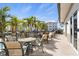 Outdoor patio featuring chairs, tables, and beautiful view of surrounding trees at 9203 Griggs Rd # B202, Englewood, FL 34224