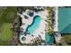 Aerial shot of pool area, featuring clear water, lounge chairs, and nearby landscaping at 9203 Griggs Rd # B202, Englewood, FL 34224