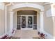 Elegant entryway with decorative iron screen doors and columns at 1010 Grouse Way, Venice, FL 34285