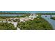 Aerial view of land with lush greenery, trails, and waterways, near a serene beach at 10382 Coquina Ct, Placida, FL 33946