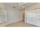 Bright bedroom with ceiling fan, tile floors, and double door closet at 1102 Auburn Cove Cir, Venice, FL 34292