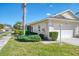 Exterior view of a villa with a white garage door and well-maintained landscaping at 1102 Auburn Cove Cir, Venice, FL 34292