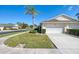 Exterior view of a single-story villa with a white garage door and landscaped lawn at 1102 Auburn Cove Cir, Venice, FL 34292