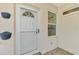 Front door entry with white door and sidelights, showing tiled flooring and wall planters at 1102 Auburn Cove Cir, Venice, FL 34292