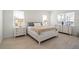 Bright bedroom features beautiful wood-look flooring and a comfortable bed with white dressers at 11140 Hogan Cir, Englewood, FL 34223