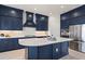 Stylish kitchen with a large island, stainless steel appliances, and navy blue cabinets at 11140 Hogan Cir, Englewood, FL 34223