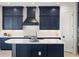 Close-up of a modern kitchen featuring navy blue cabinets, white backsplash, and white countertop at 11140 Hogan Cir, Englewood, FL 34223