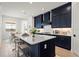 Spacious kitchen island with bar stool seating and navy blue cabinets at 11140 Hogan Cir, Englewood, FL 34223
