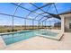 Stunning screened-in pool area with spa and view of the open backyard and blue sky at 11140 Hogan Cir, Englewood, FL 34223