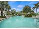 Spacious swimming pool surrounded by palm trees and lounge chairs under a bright sky, perfect for relaxation at 11140 Hogan Cir, Englewood, FL 34223
