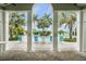 Relaxing pool area surrounded by lush palm trees and comfortable lounge chairs, as seen from a covered area at 11140 Hogan Cir, Englewood, FL 34223