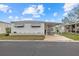 Single-wide mobile home with carport and landscaped yard at 115 White Oak Way, Sarasota, FL 34237