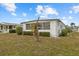 White single-wide home with landscaped yard at 115 White Oak Way, Sarasota, FL 34237