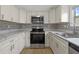 Modern kitchen with white cabinets and stainless steel appliances at 115 White Oak Way, Sarasota, FL 34237