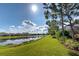 Spacious backyard with pond view, lush landscaping, and screened patio at 11692 Spotted Margay Ave, Venice, FL 34292