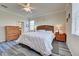 King-size bed, wood furniture, and large windows in this bright bedroom at 11692 Spotted Margay Ave, Venice, FL 34292