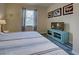 Bedroom with light blue and white bedding, wood-look flooring, and a TV at 11692 Spotted Margay Ave, Venice, FL 34292