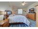 Bright bedroom featuring a king bed, wood dresser, and ceiling fan at 11692 Spotted Margay Ave, Venice, FL 34292