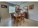 Elegant dining room with a wooden table and chairs, hardwood floors, and artwork at 11692 Spotted Margay Ave, Venice, FL 34292