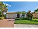 Single-story house with beige walls, tile roof, and a two-car garage at 11692 Spotted Margay Ave, Venice, FL 34292