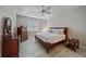 Main bedroom with a king-size bed and wood furniture at 12029 Tapestry Ln, Venice, FL 34293