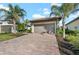 House exterior showcasing a brown garage door and palm trees at 12861 Oriago St, Venice, FL 34293