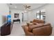 Open living area with leather sofas, a large TV, and ceiling fan at 12861 Oriago St, Venice, FL 34293