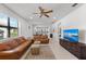 Bright living room features brown leather couches, a large TV, and tile floors at 12861 Oriago St, Venice, FL 34293