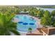 Freeform community pool with blue umbrellas and palm trees at 12861 Oriago St, Venice, FL 34293