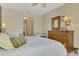 King-size bed in a well-lit bedroom with wood dresser at 1375 Maseno Dr, Venice, FL 34292