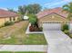 Single-story home with tile roof, two-car garage, and landscaped yard at 1375 Maseno Dr, Venice, FL 34292
