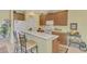 Well-equipped kitchen with light wood cabinets and a breakfast bar at 1375 Maseno Dr, Venice, FL 34292