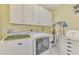 Bright laundry room with washer, dryer, and ample cabinets at 1375 Maseno Dr, Venice, FL 34292