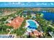 Beautiful community aerial view showcasing the clubhouse, pool, water features, tennis courts, and lush landscaping at 18861 Bianchi St, Venice, FL 34293